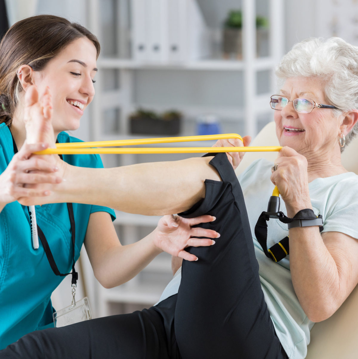 Elderly woman exercising leg with band